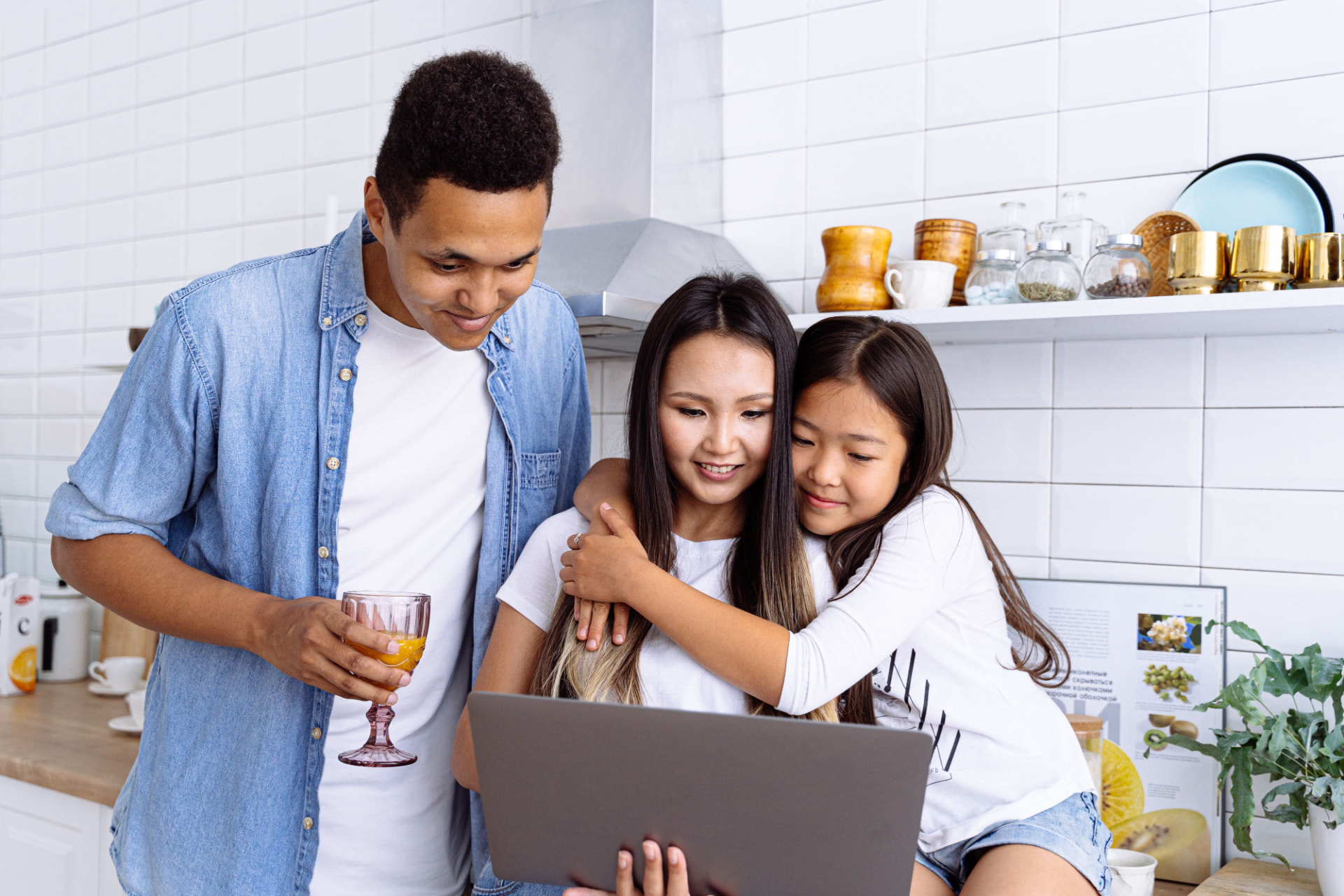Family looking at a laptop together in a bright kitchen